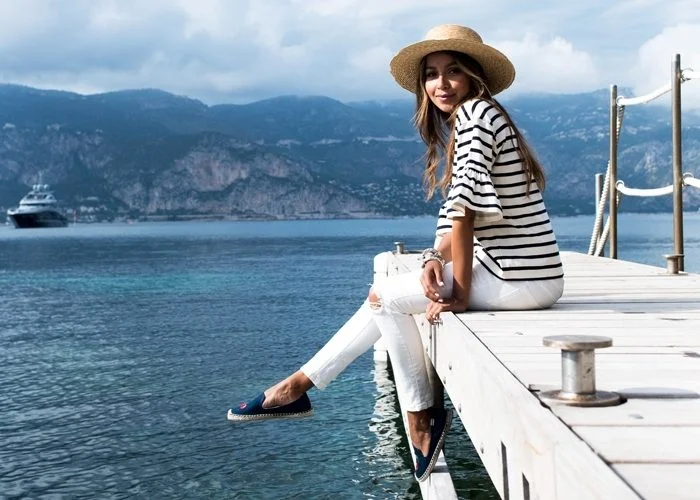 Julie Sariñana of @sincerelyjules on the dock of a Mediterranean bay wearing Soludos.