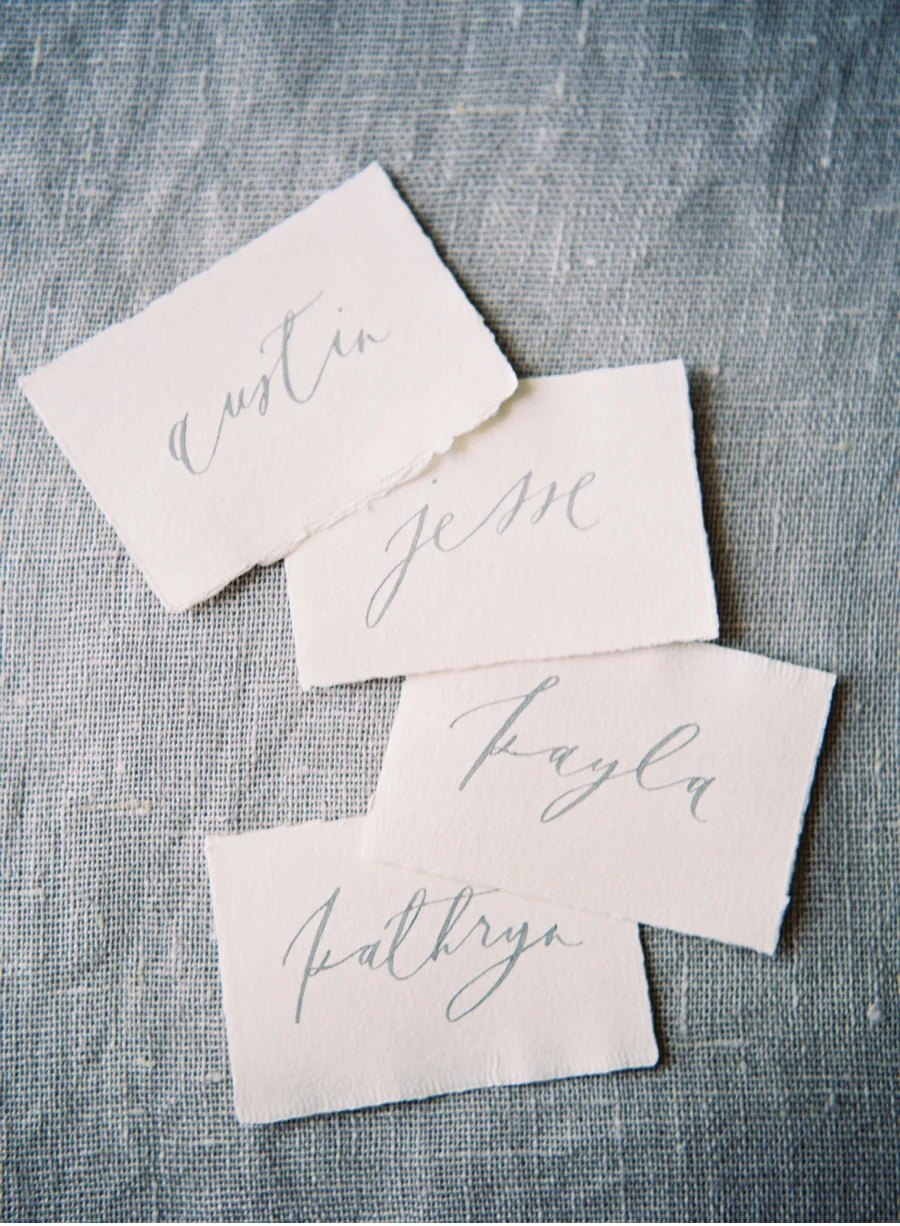 4. Simple escort or place cards featuring elegant script on rustic deckle-edged paper is anything but plain.  Calligraphy by Brown Linen Design with photography by Heather Payne Photography for the Team Flower Workshop.…