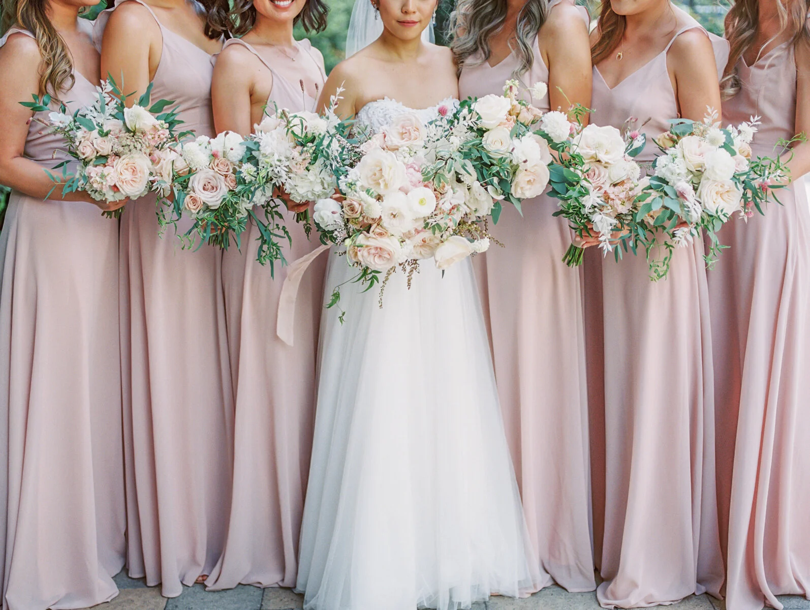 Bridesmaids in blush and dusty rose dresses