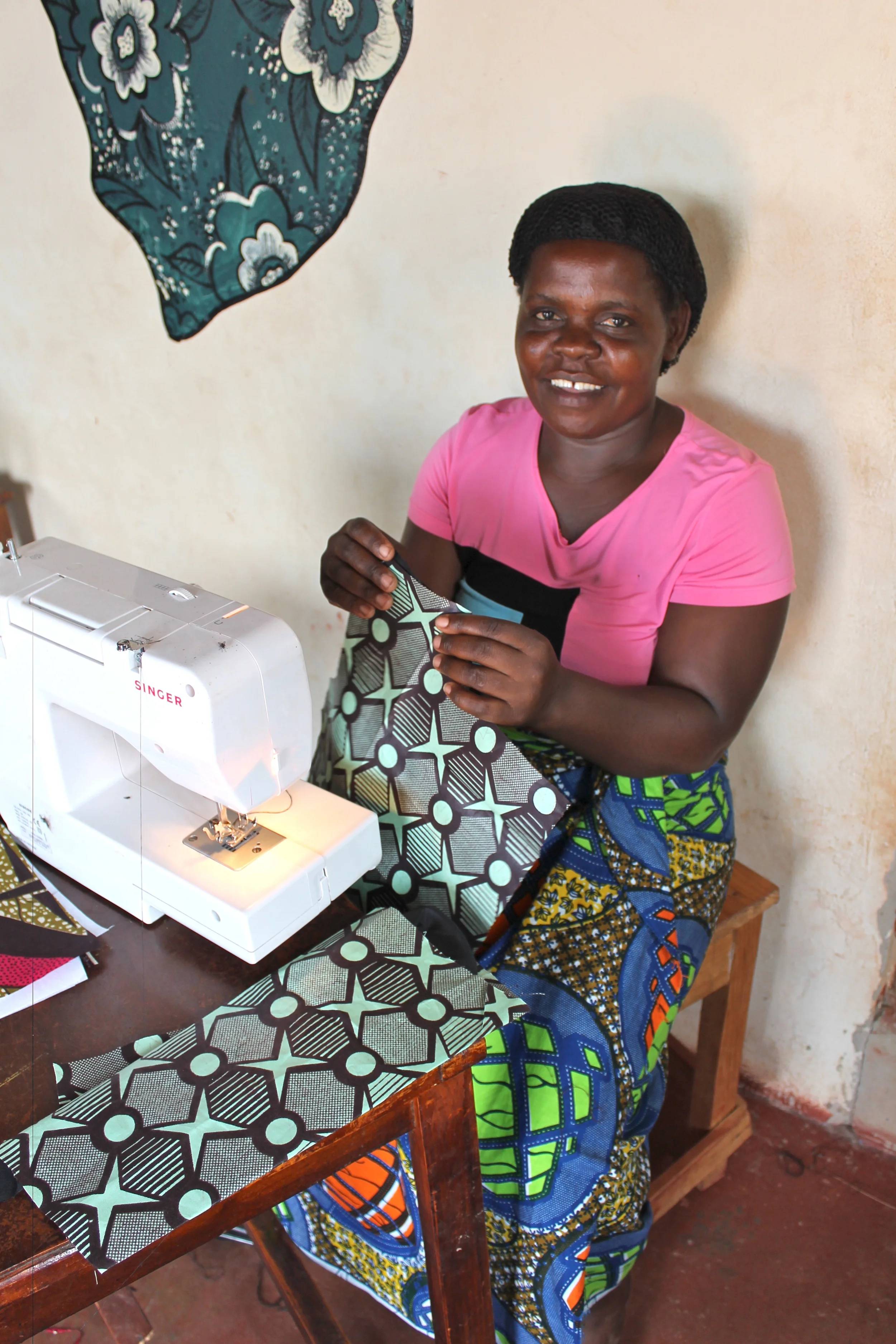 Martha sewing her personally-designed suit to wear for her Graduation Ceremony this upcoming weekend