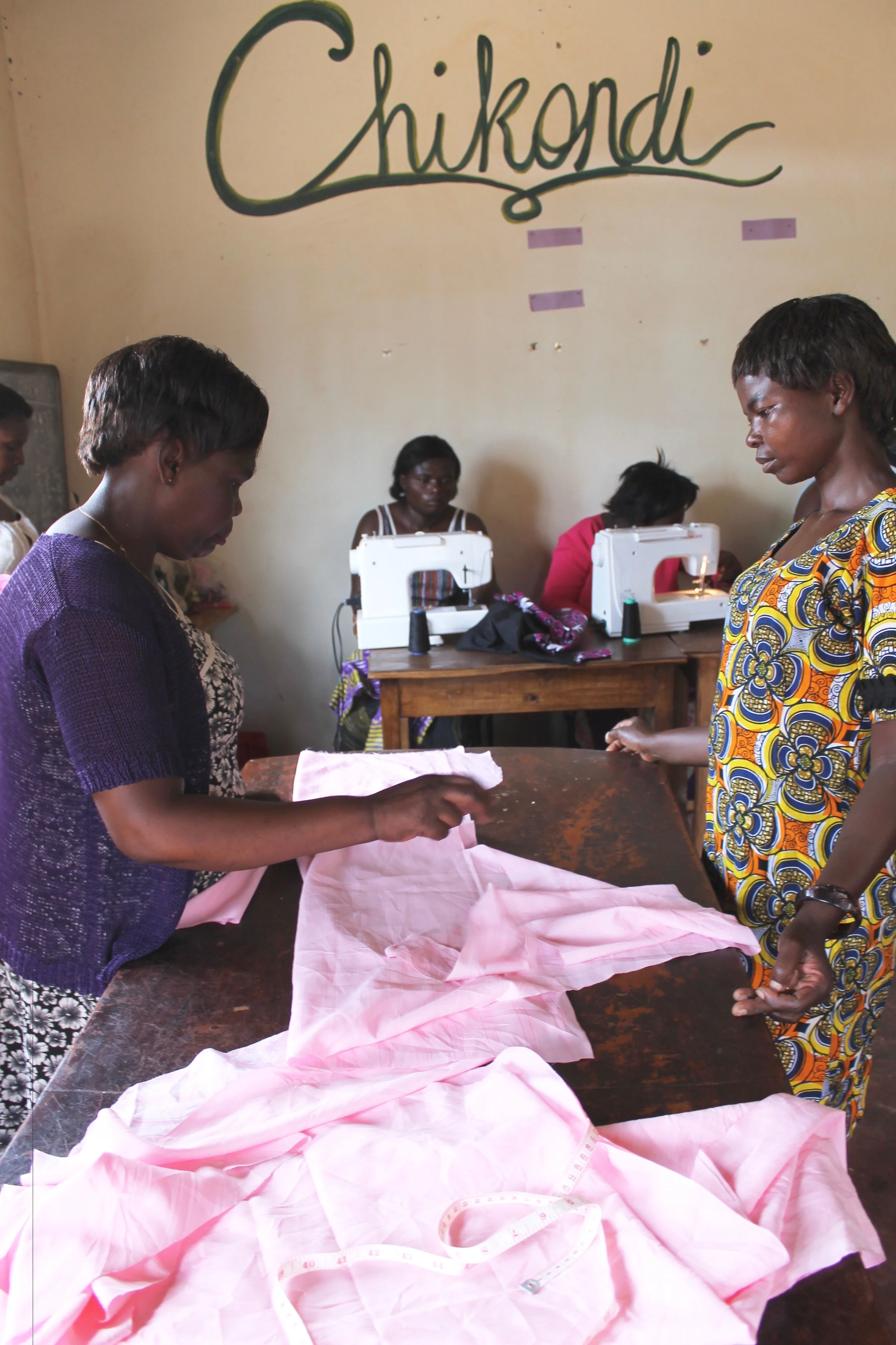 Lead Instructor Mrs. Mulenga helps Tresa as students bring in their own patterns and garments for design and sewing questions.