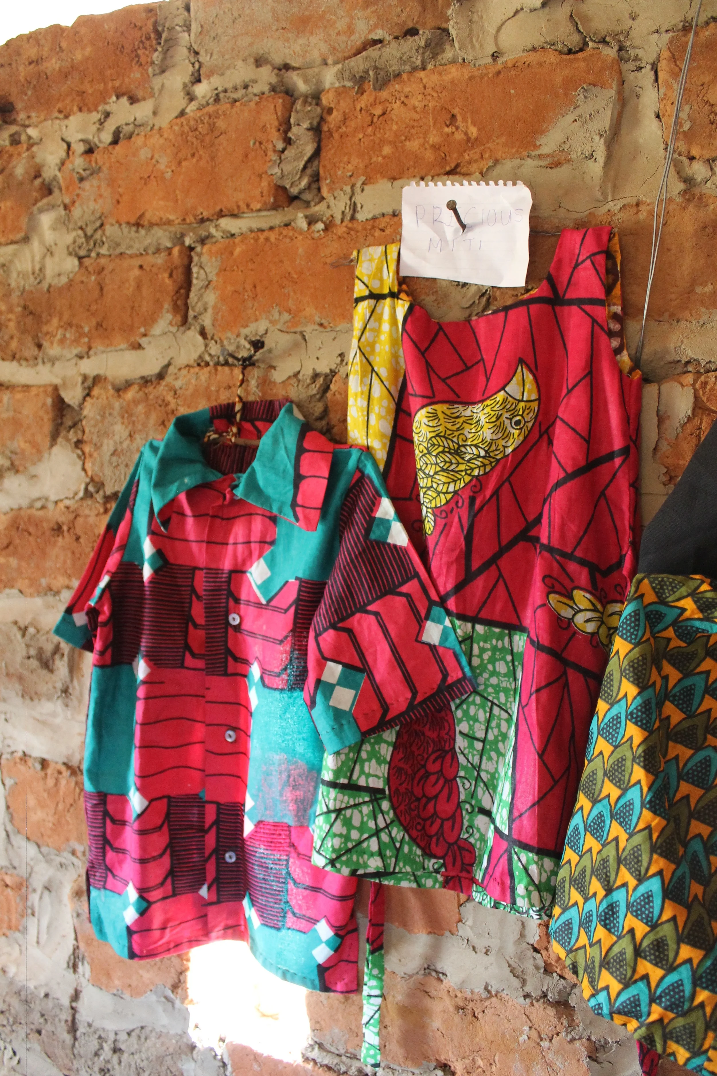 This is Precious' display of her graduation testing garments. Each woman made these without electricity, without a fancy machine, many of them stitching garments entirely by hand without patterns. Incredible stuff right there. 
