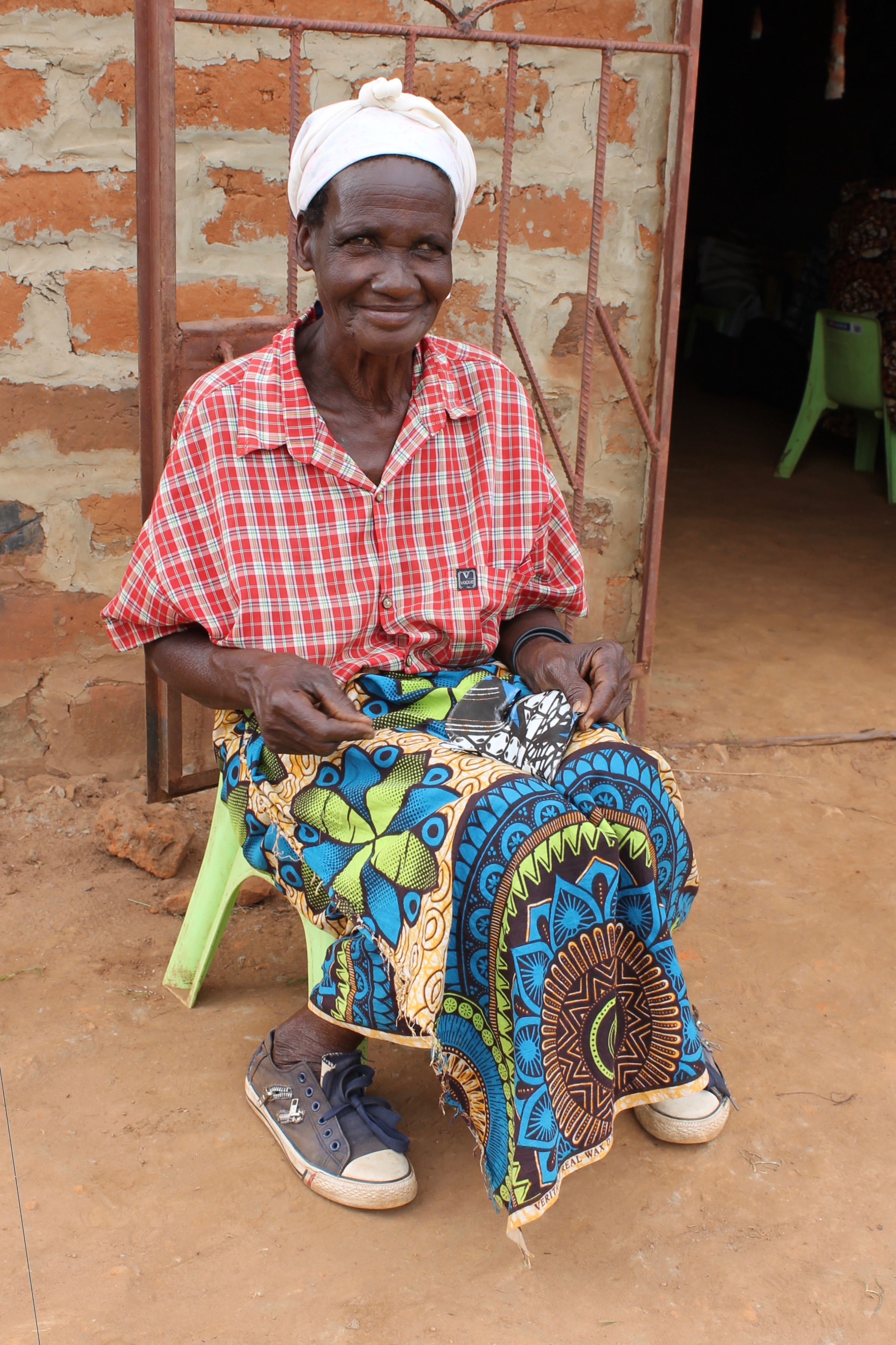 Meanwhile, Elizabeth Muchochoma, oldest woman in Muchochoma Village at 55 years old, hand-sewed some product samples outside.