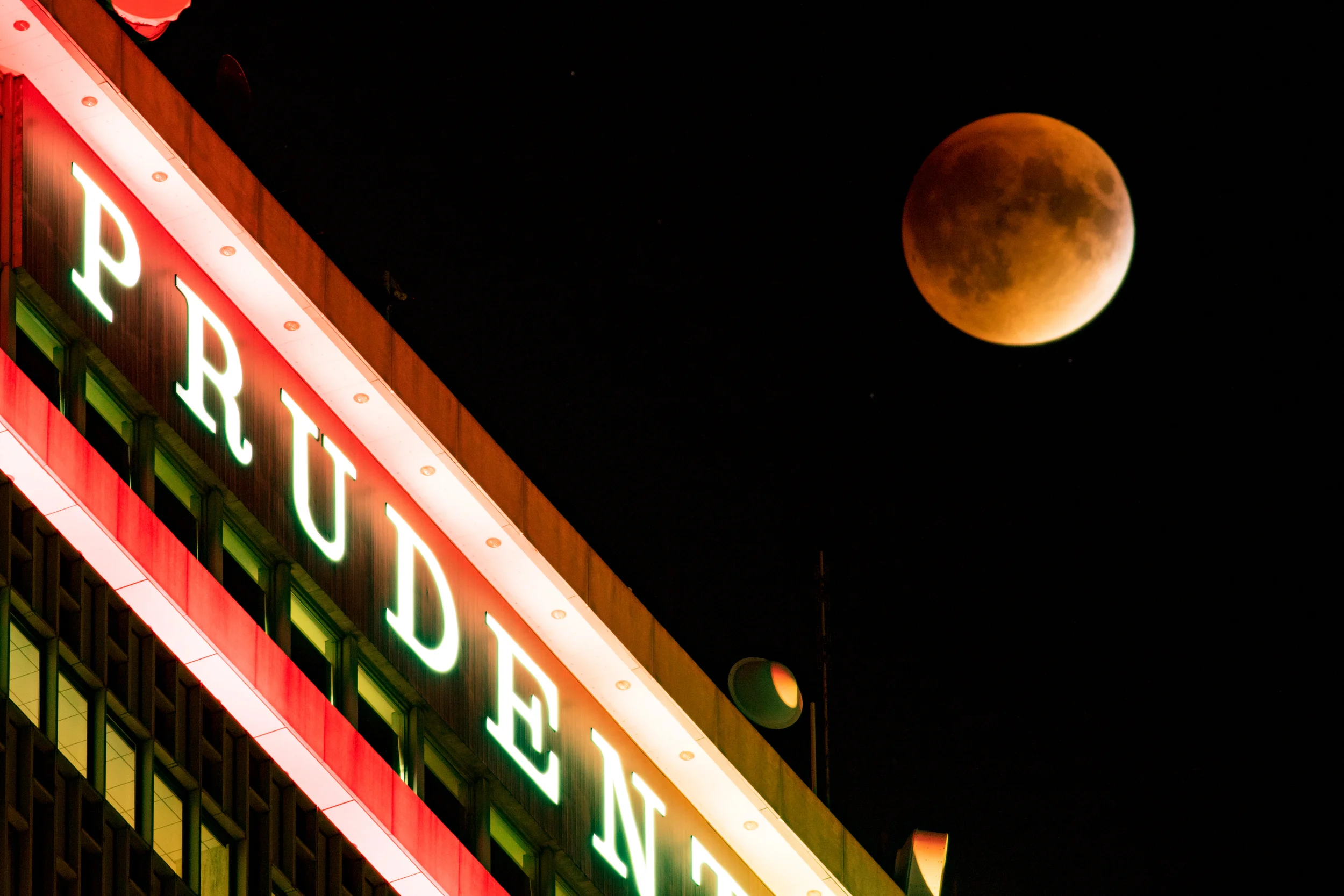 Close up the the moon over the Prudential Building in Boston
