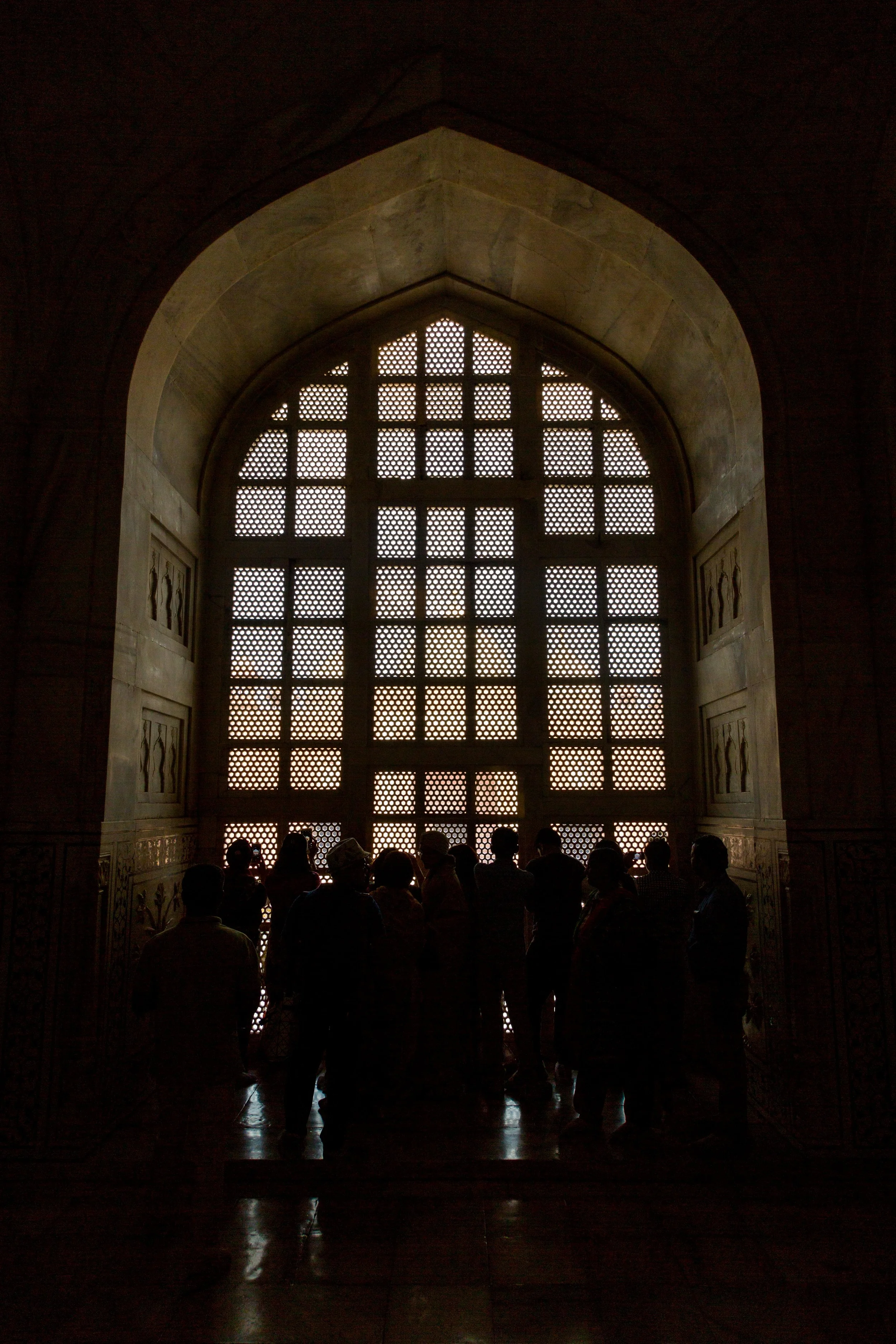 A crowd of people admire the Jali in the window of the Taj Mahal. Jali is the stonework done to make it easier to see out than it is to see in. The original two way mirror.