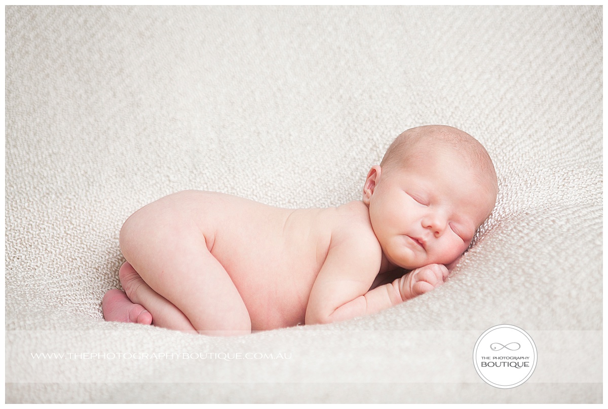 newborn baby studio pose on natural blanket