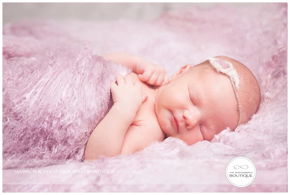 newborn sleeping relaxed pose with pink wool blanket