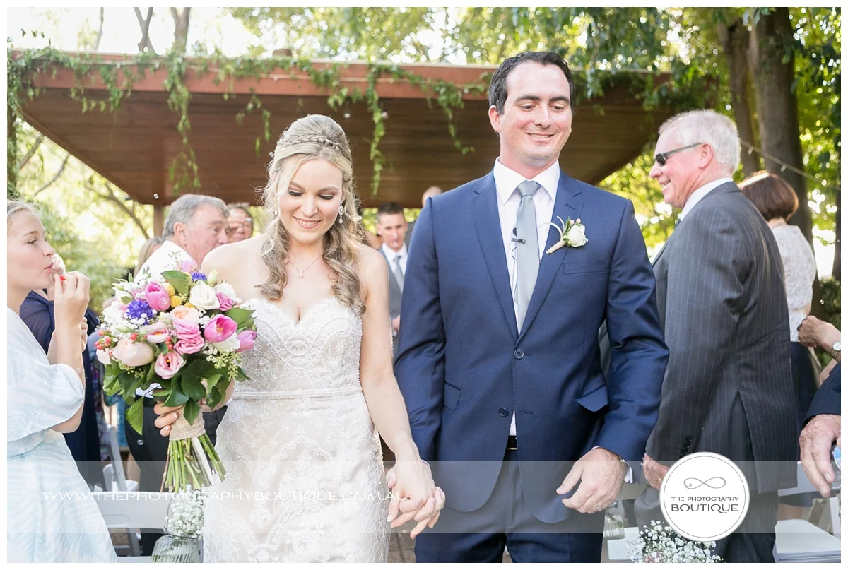 Bride and groom walking down the aisle at chandeliers on abbey margaret river