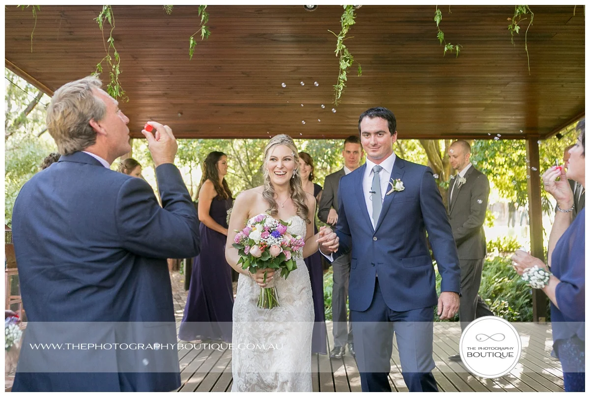 guests blowing bubbles as bride and groom walk back down the aisle at chandeliers on abbey margaret river