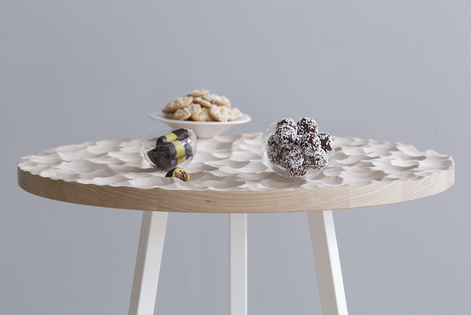 Umami café Table and table top items, 2015 A café table with custom table top items in handmade ceramic and glass, that fit perfectly into the three dimensional structure. Umami café is a development of the project Umami. The table top items for Umami café are the same as for Umami. Material: ash, steel, hand blown glass and ceramics Table: Ø 700 mm, h 720 mm Glass bowl, small: Ø 90 mm, h 60 mm Glass bowl medium: Ø 110 mm, h 70 mm Glass bowl, large: Ø 130 mm, h 85 mm Ceramic serving plate: Ø 195 mm, h 55 mm Photo: Petter Brandt