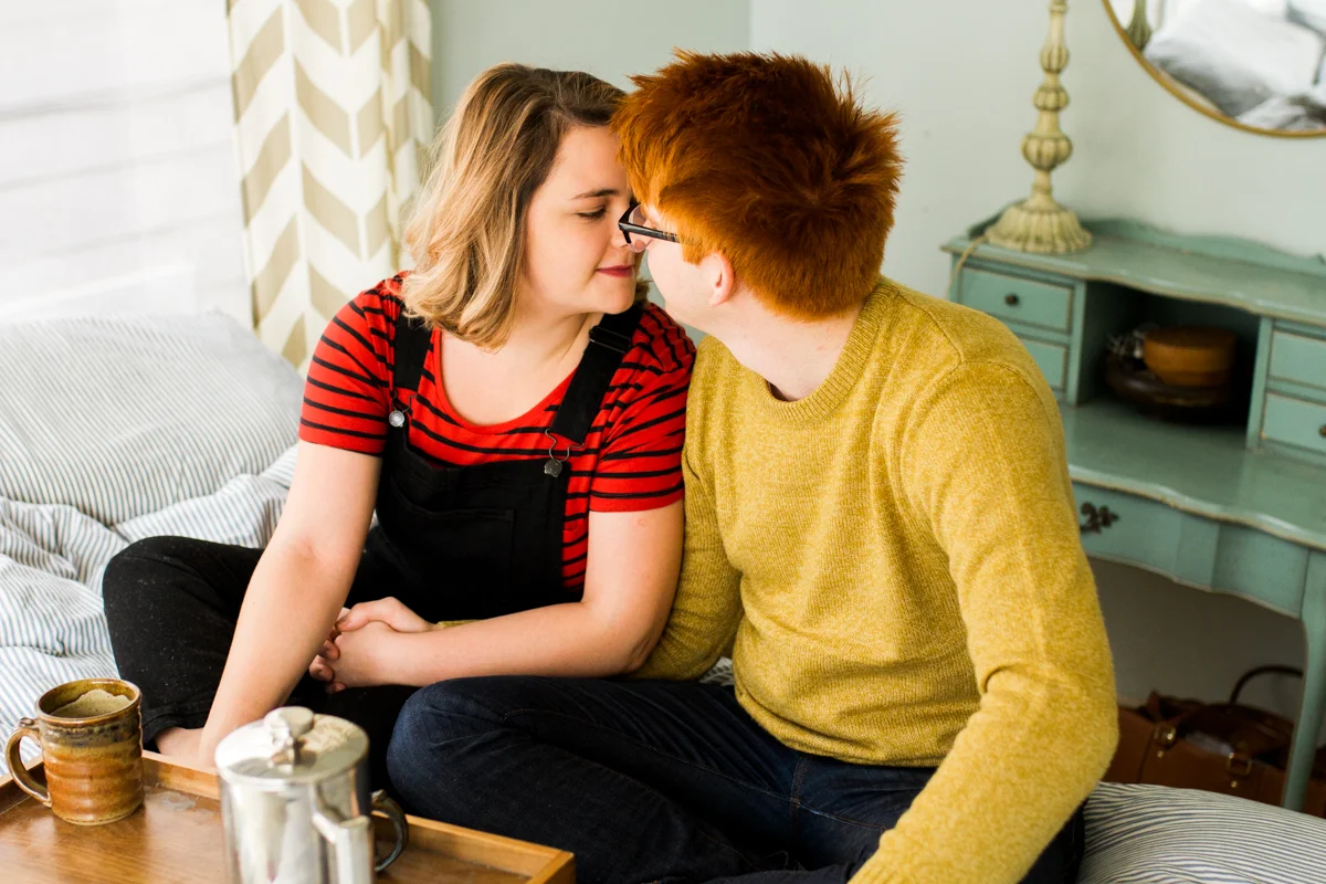 leaning in to kiss during an intimate in-home couples session in Kansas City, MO