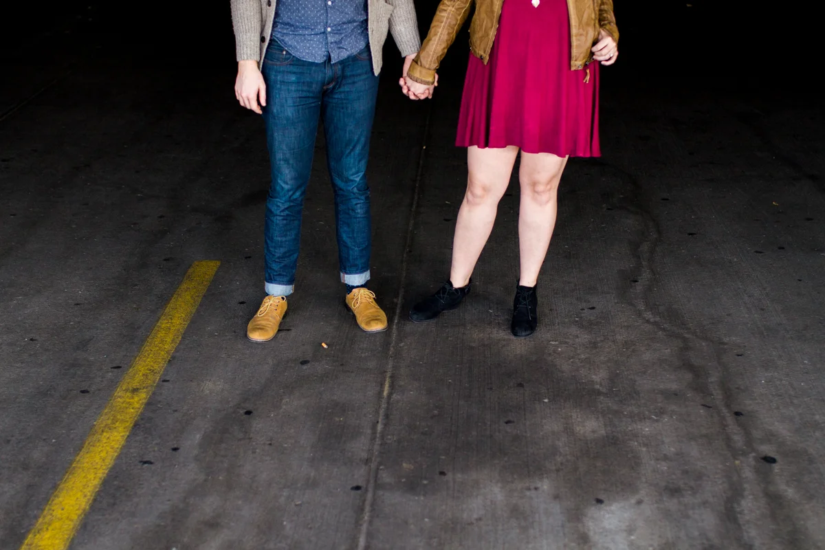 engaged or married couple holding hands in a parking garage in Westport Kansas City, MO