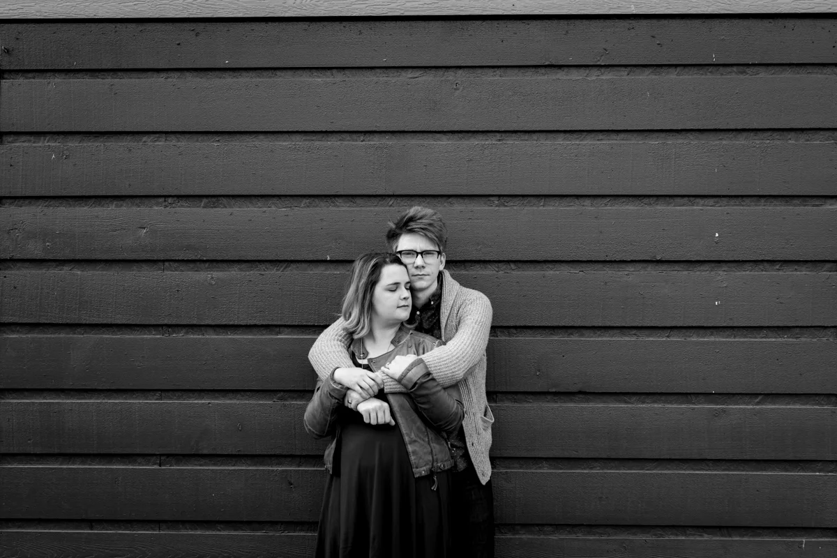 urban engaged or married couple leaning against gray wall engagment photography couples photography Westport Kansas City, MO