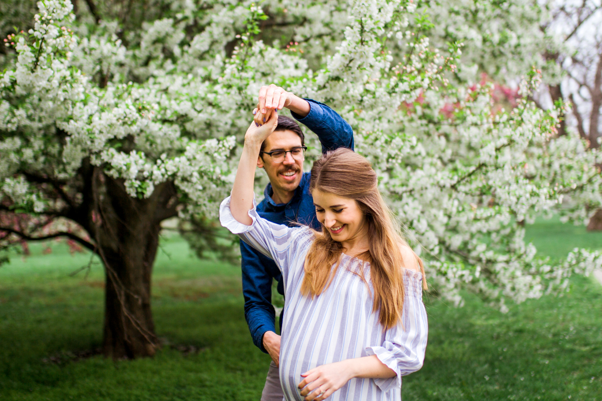  Kansas City Loose Park spring maternity session dancing by the flowering apple tree Kansas City maternity photographer 