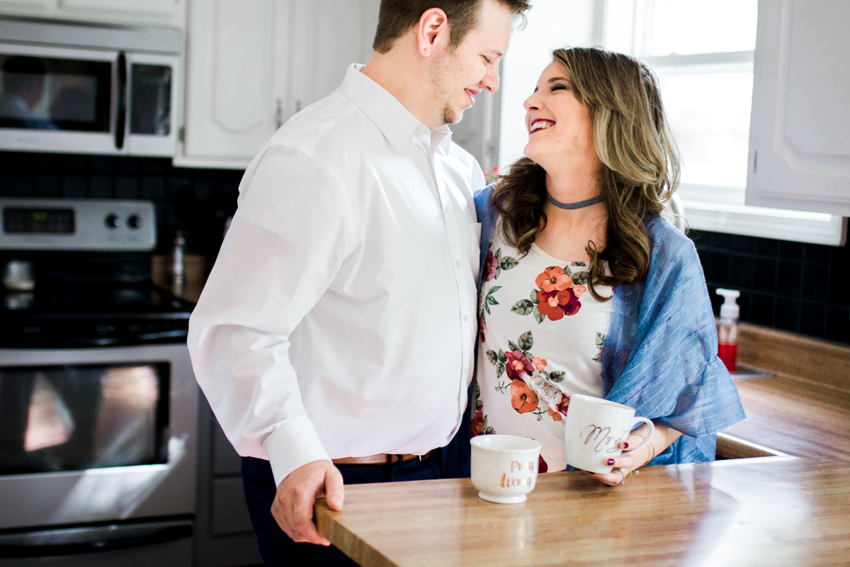 Kansas City lifestyle photographer in home couples session cuddling in the kitchen with coffee engagement photos black and white photo