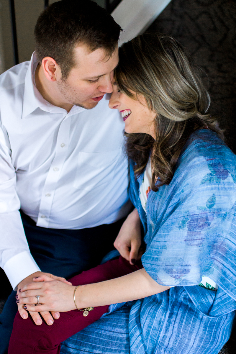  Kansas City lifestyle photographer in home couples session cuddling and laughing on the stairs engagement photos 