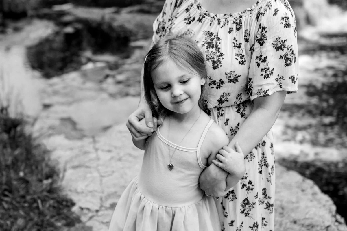 Rebecca Clair Photography Kansas City MO lifestyle family photographer Line Creek Trail Family Session mother and daughter cuddling together black and white photo