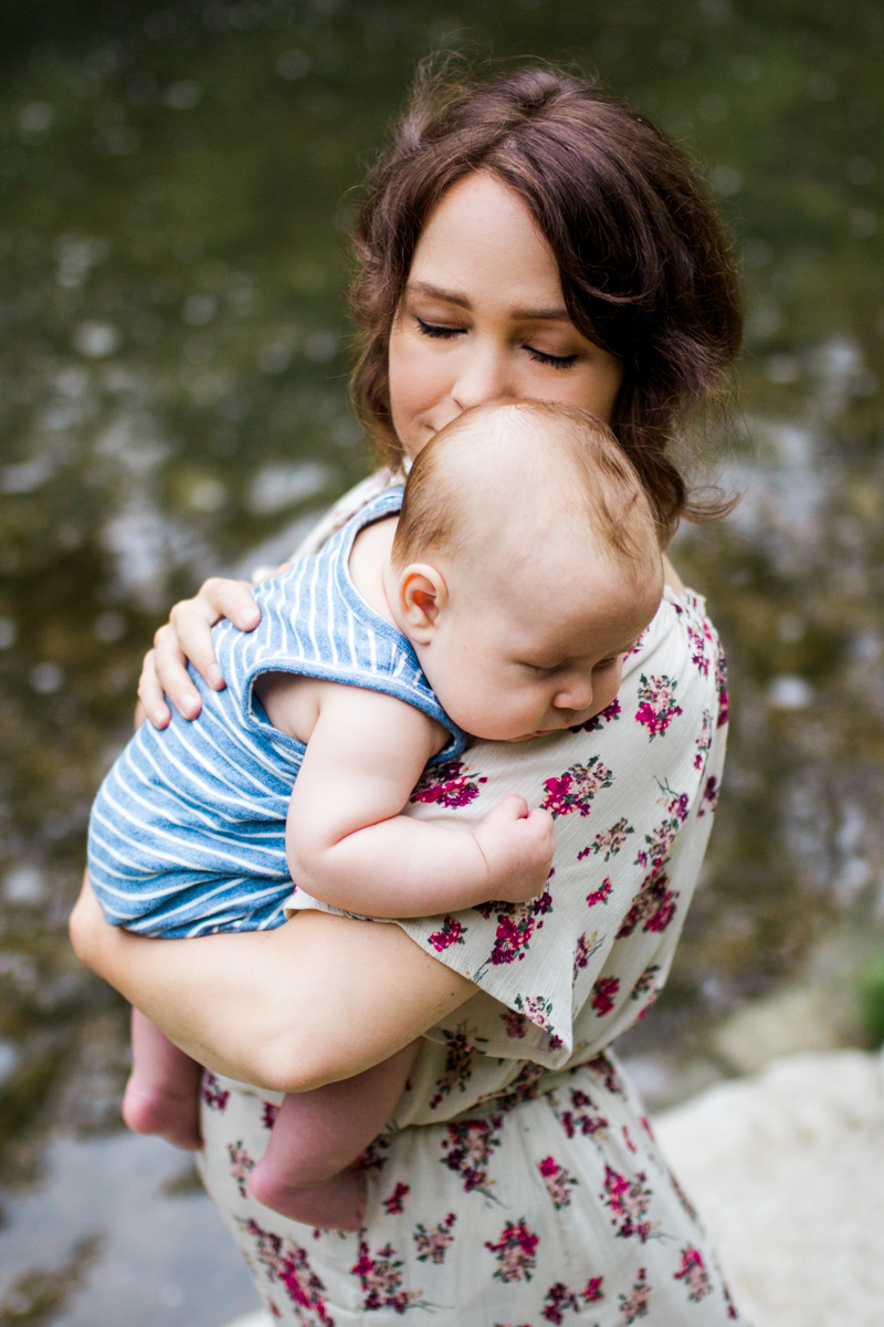  Rebecca Clair Photography Kansas City MO lifestyle family photographer Line Creek Trail Family Session close up of mother holding baby by the creek 