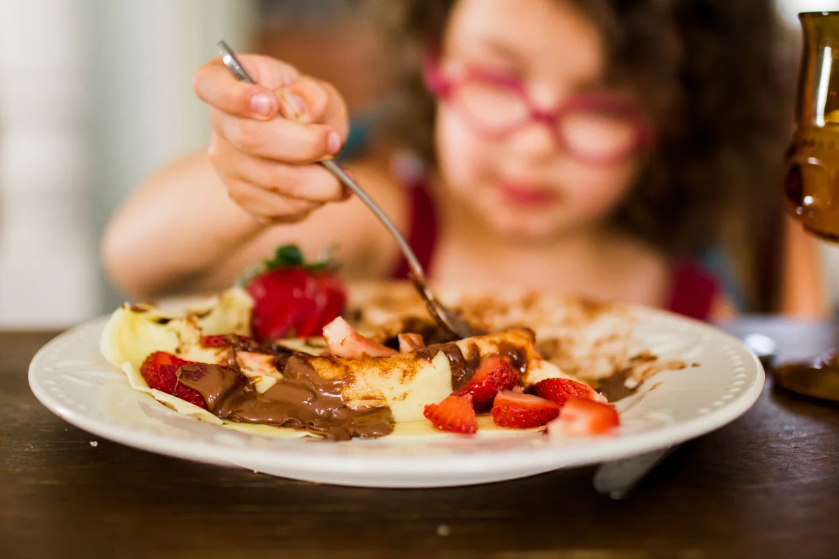 Kansas City small business lifestyle photography seven swans creperie girl eating crepe dinner party