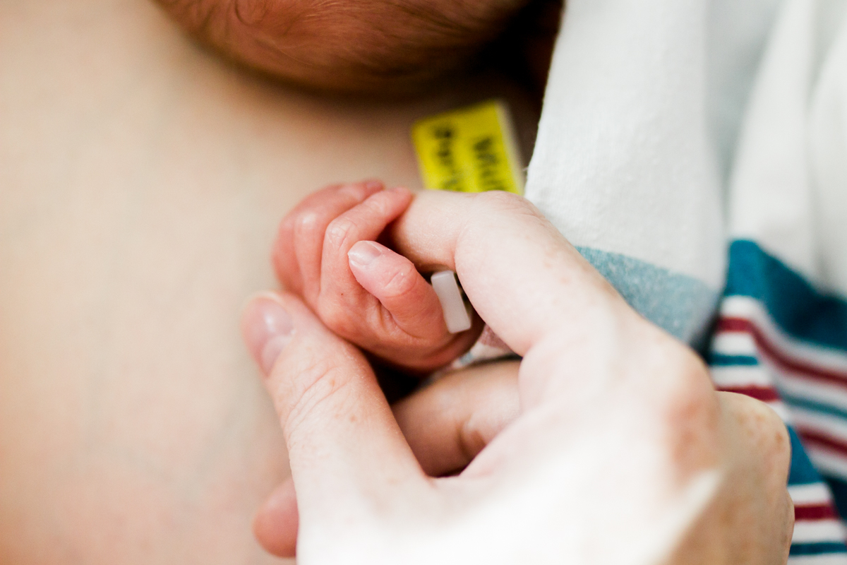  Rebecca Clair Photography lifestyle NICU newborn photography Children's Mercy Hospital newborn baby fingers mom holding baby's hand 