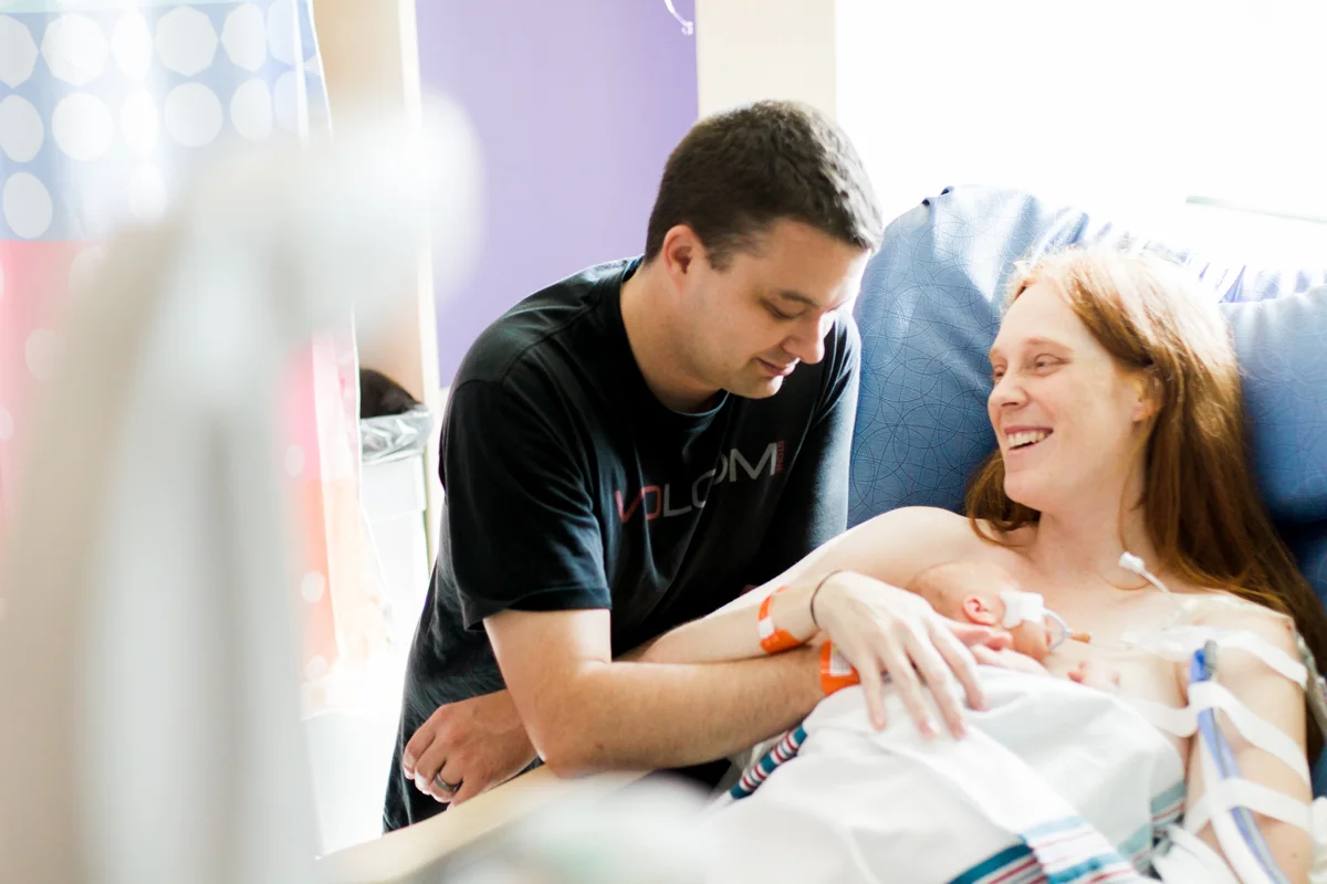 Rebecca Clair Photography lifestyle NICU newborn photography Children's Mercy Hospital parent laughing with their baby