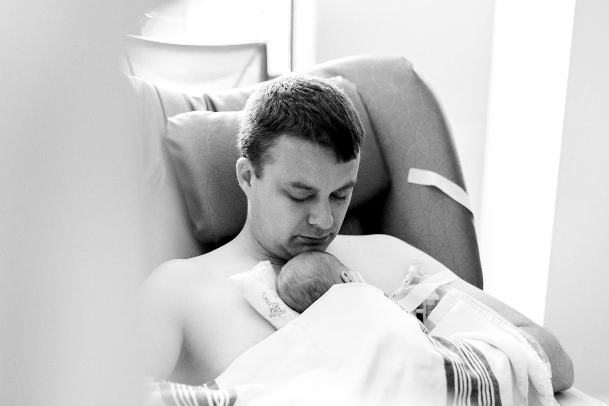  Rebecca Clair Photography lifestyle NICU newborn photography Children's Mercy Hospital father doing skin to skin with his baby black and white photo 