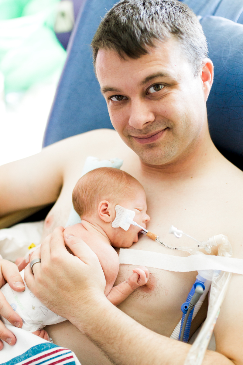  Rebecca Clair Photography lifestyle NICU newborn photography Children's Mercy Hospital father doing skin to skin with his baby 