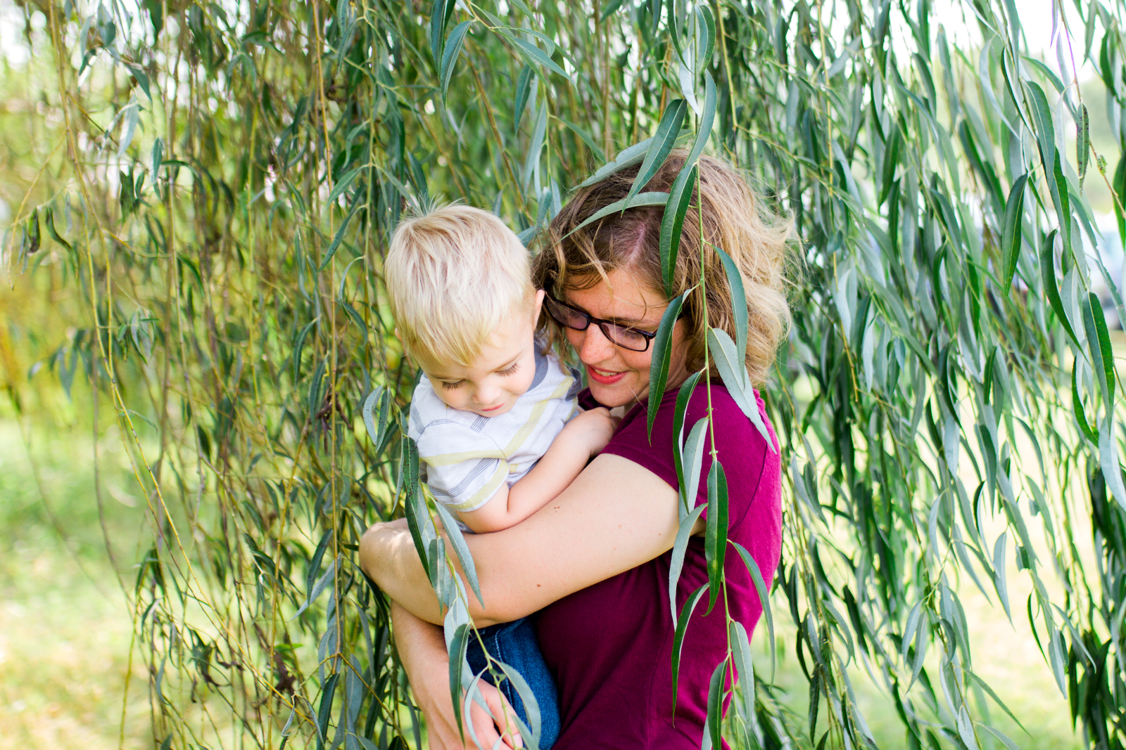  Rebecca Clair Photography, Kansas City lifestyle photographer, apple picking photo session, apple orchard photos, Kansas City family photographer, mother holding son in willow trees 