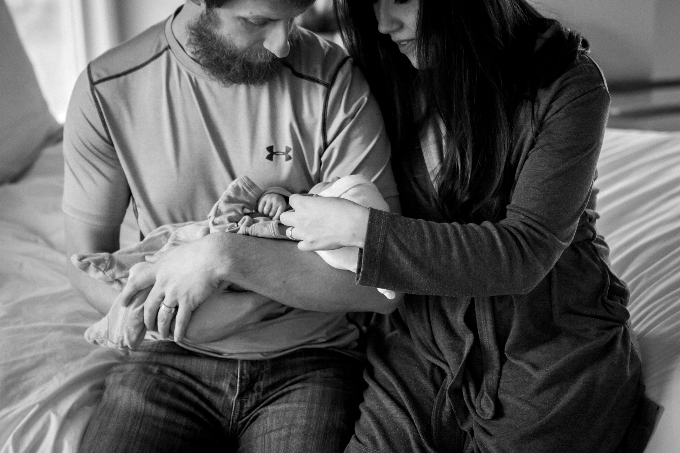  Kansas City lifestyle newborn photographer, Kansas City newborn photographer, Kansas City newborn photos, Kansas City in-hom newborn session, parents cuddling baby on bed, black and white photo 