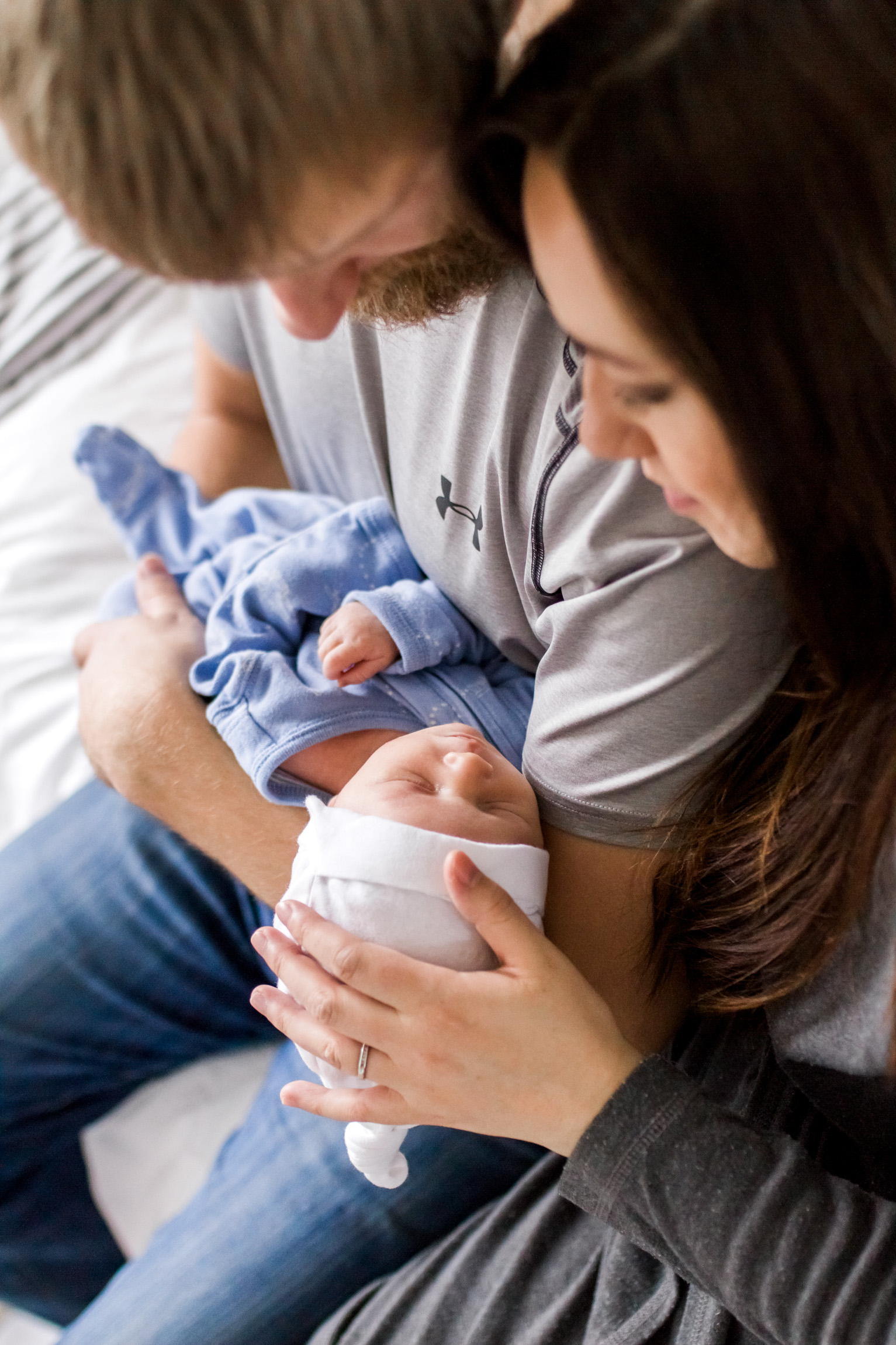  Kansas City lifestyle newborn photographer, Kansas City newborn photographer, Kansas City newborn photos, Kansas City in-hom newborn session, parents cuddling baby on bed 