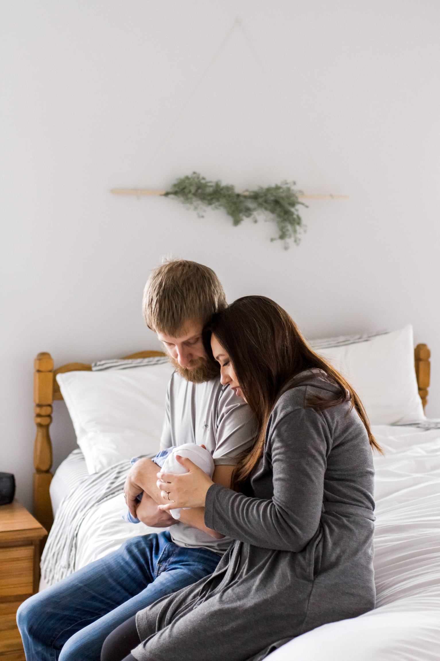  Kansas City lifestyle newborn photographer, Kansas City newborn photographer, Kansas City newborn photos, Kansas City in-hom newborn session, parents cuddling baby on bed 