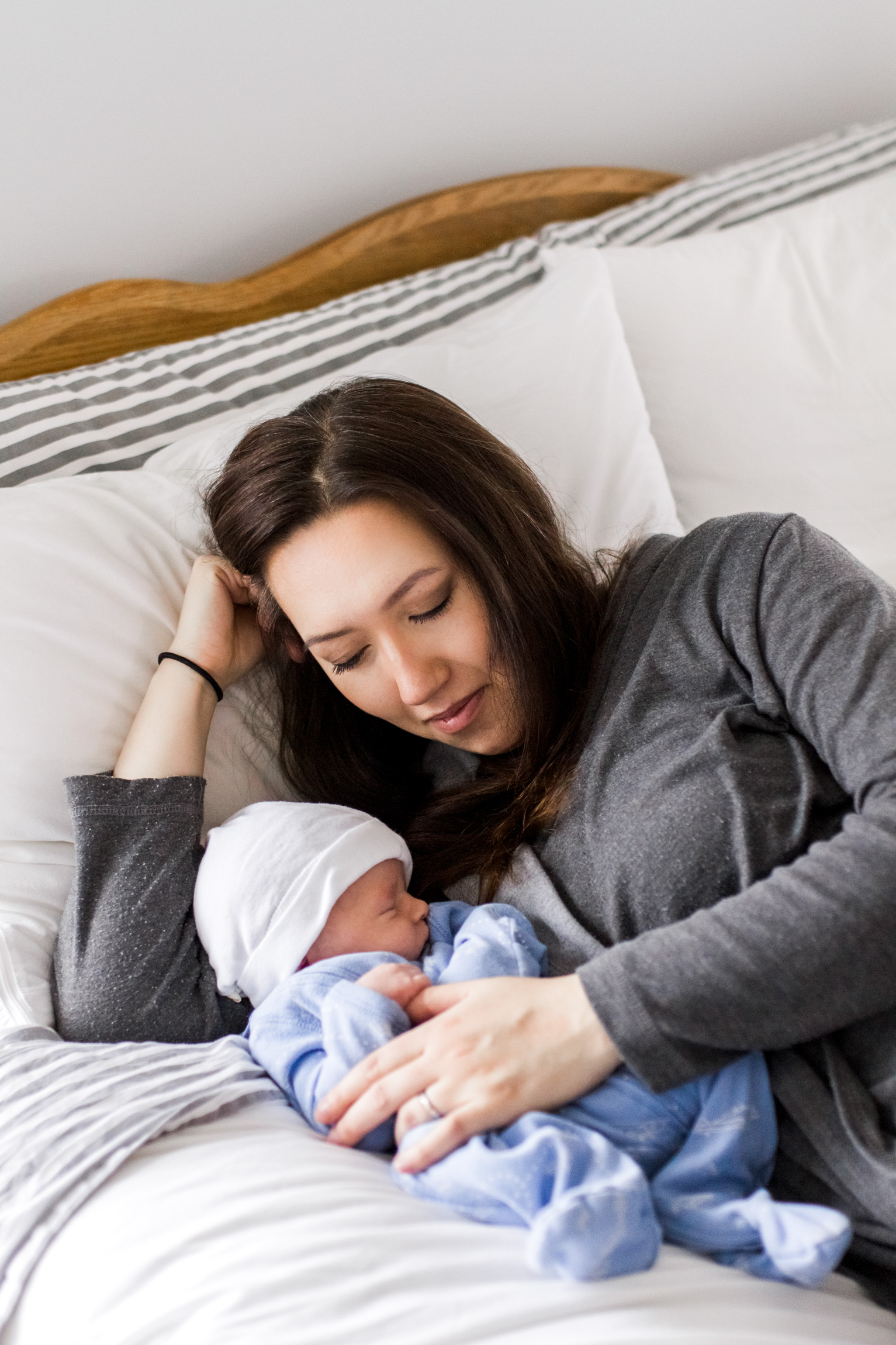  Kansas City lifestyle newborn photographer, Kansas City newborn photographer, Kansas City newborn photos, Kansas City in-hom newborn session, mother cuddling baby on bed 