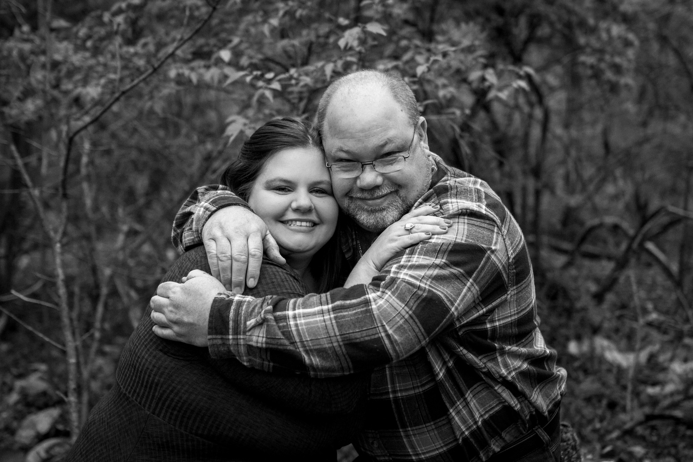  Kansas City lifestyle photographer, Kansas City family photographer, extended family session, fall family photos in the woods, father and grown daughter hugging, black and white photo 