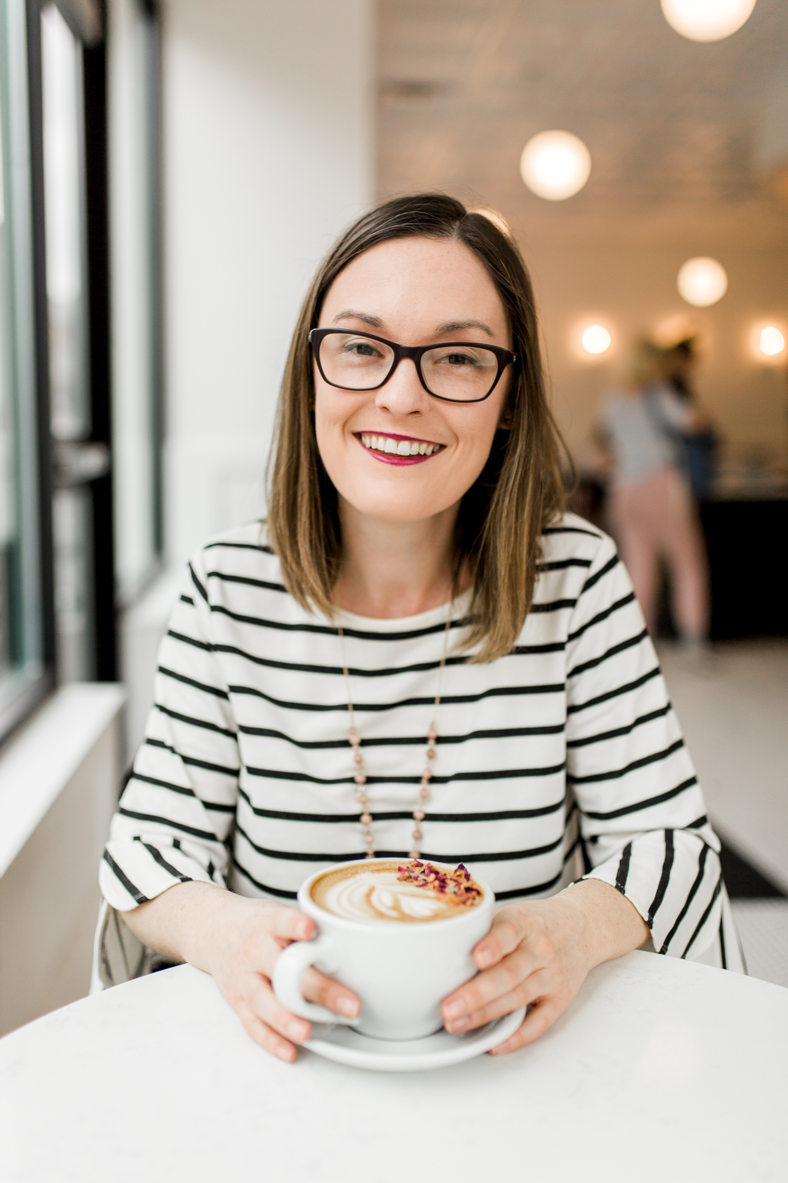  Smiling woman drinking a latte in a coffee shop, Kansas City lifestyle photographer, Kansas City senior photographer, Kansas City small business headshots, Kansas City lifestyle blogger, candid portrait, winter portrait session, Monarch Coffee 