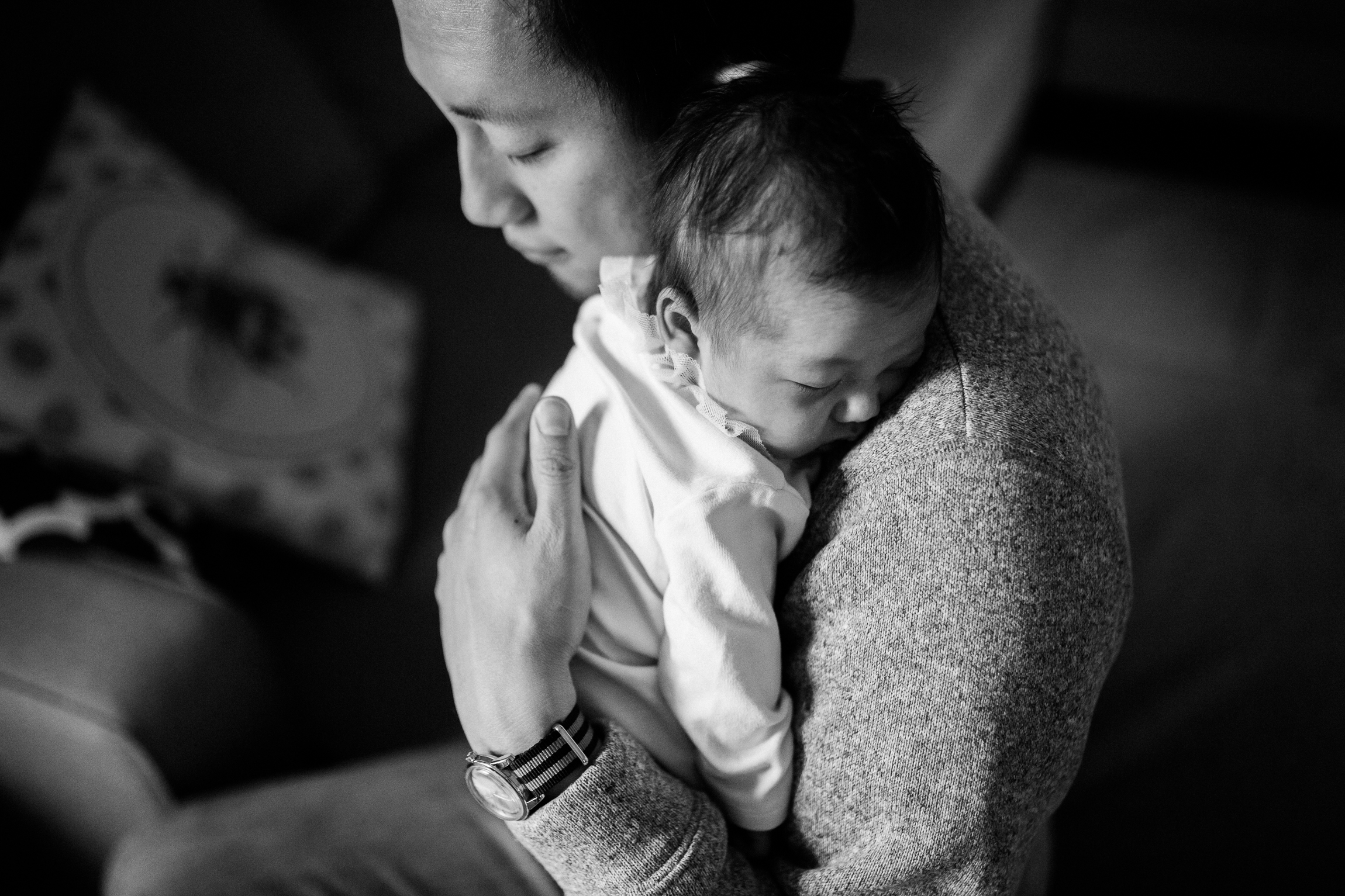  black and white portrait of father cuddling his newborn daughter, Kansas City lifestyle newborn photographer, in-home newborn session 