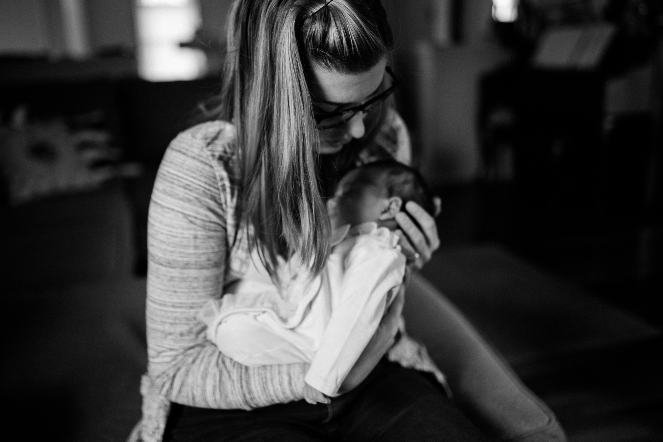  black and white portrait of mother cuddling her newborn daughter, Kansas City lifestyle newborn photographer, in-home newborn session 