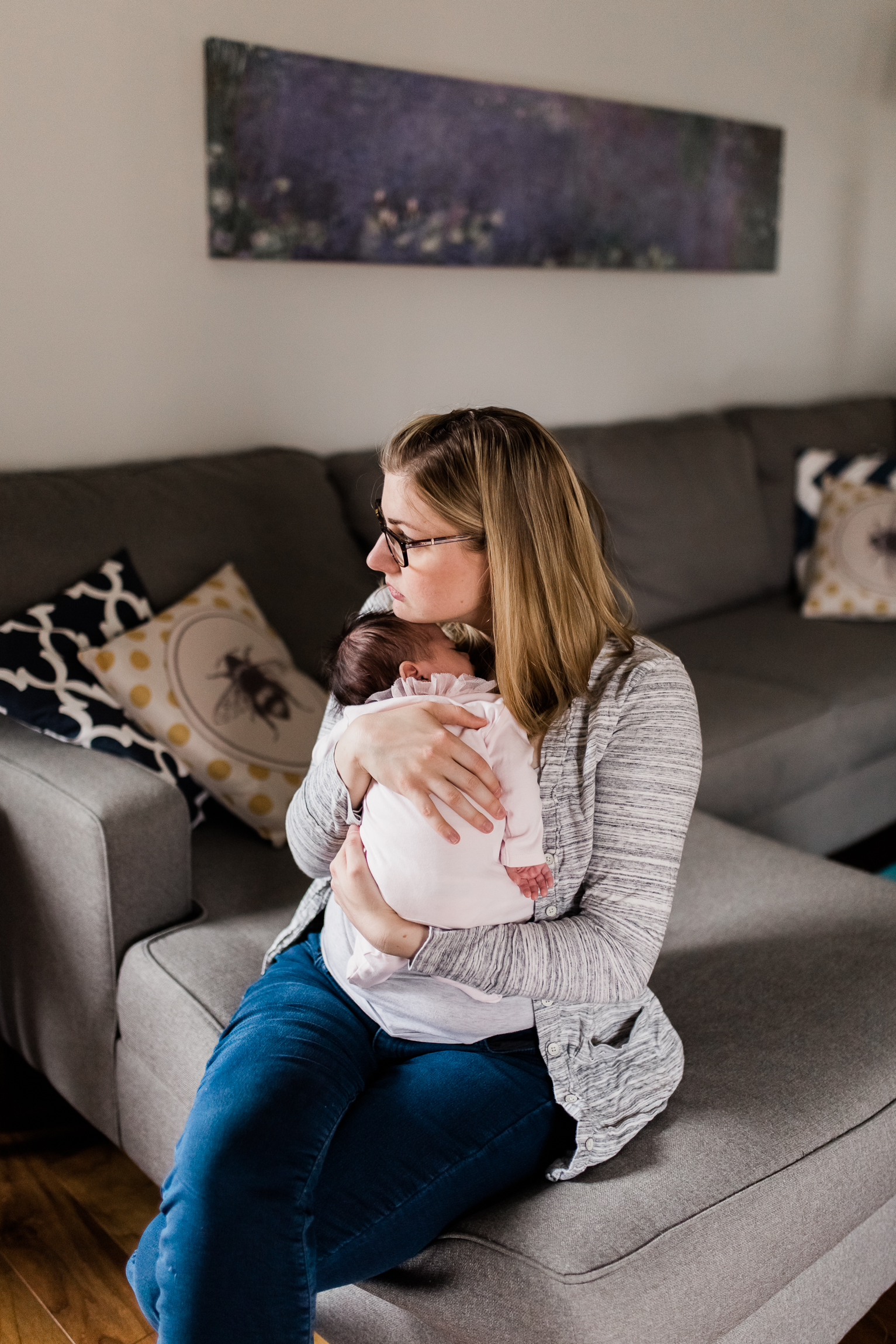  portrait of mother cuddling her newborn daughter in the living room, Kansas City lifestyle newborn photographer, in-home newborn session 