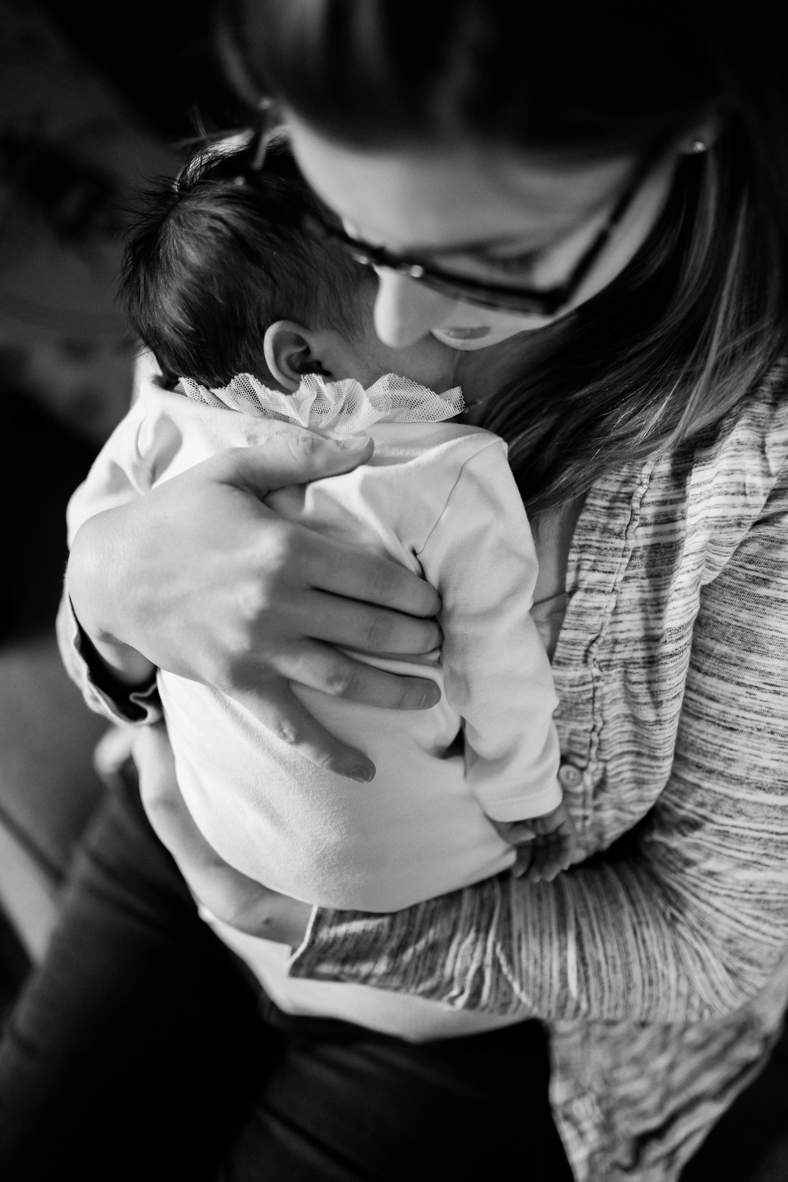  black and white portrait of mother cuddling her newborn daughter, Kansas City lifestyle newborn photographer, in-home newborn session 