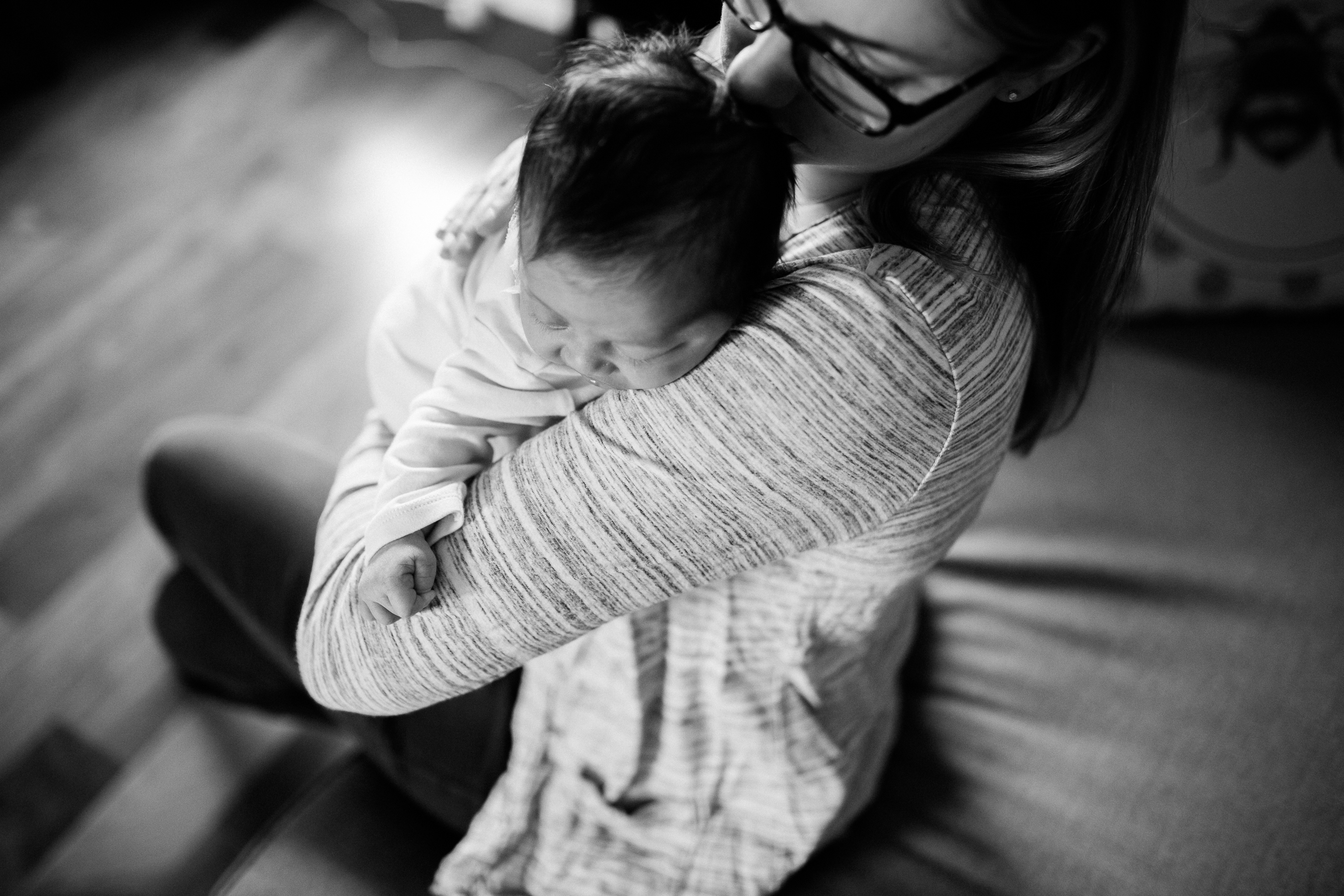  black and white portrait of mother cuddling her newborn daughter, Kansas City lifestyle newborn photographer, in-home newborn session 