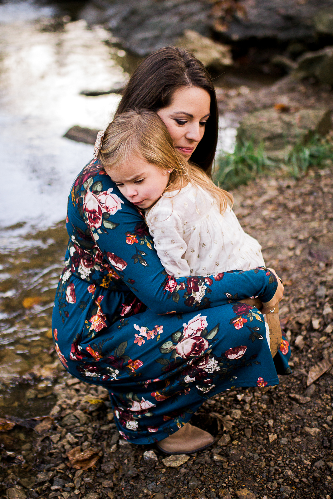  Mother embraces daughter by the stream, candid family photography, Shawnee Mission park sunrise session, Rebecca Clair Photography 