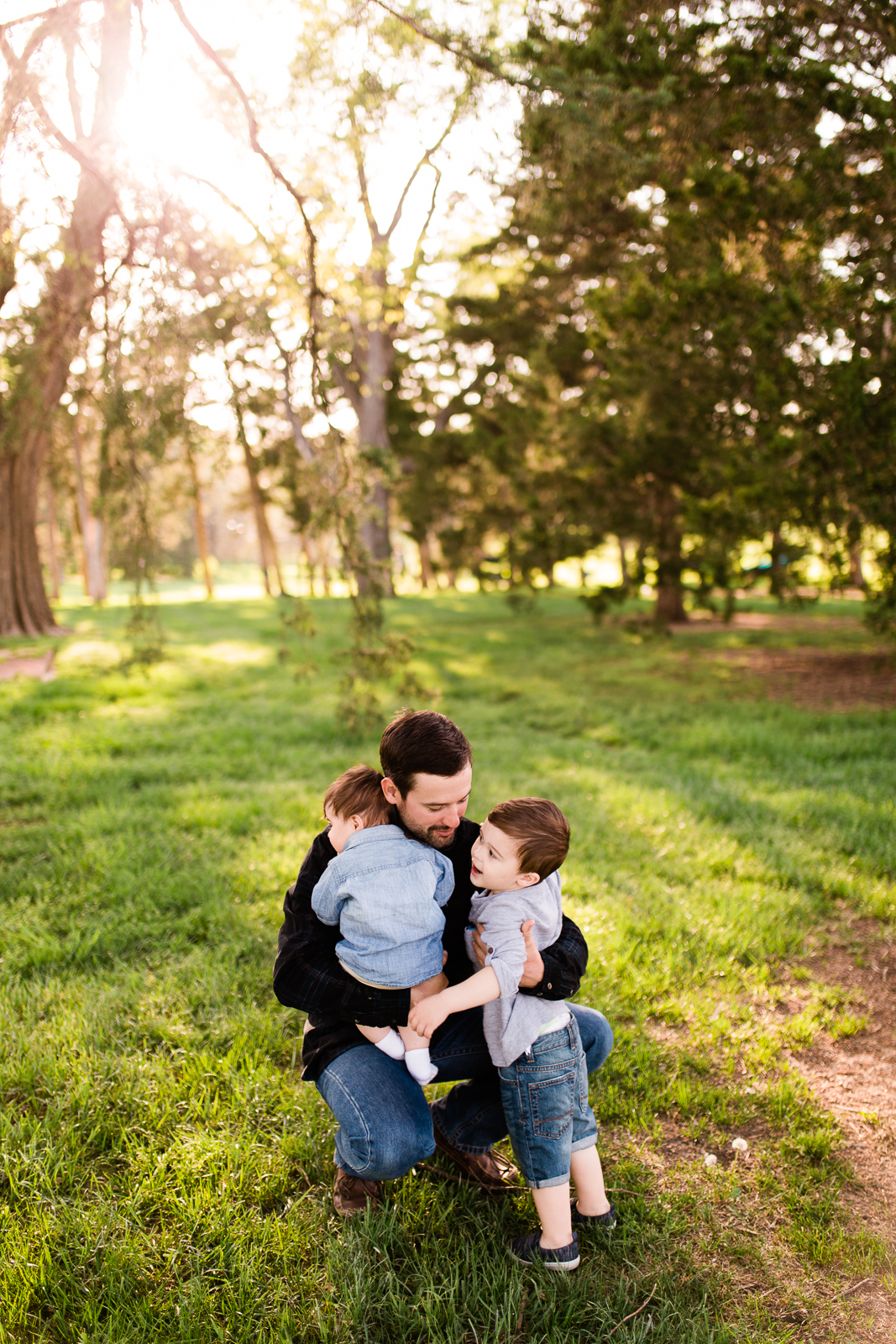  Father cuddles his sons in the evening light, Loose Park family session at golden hour, Kansas City family photographer, Rebecca Clair Photographer 