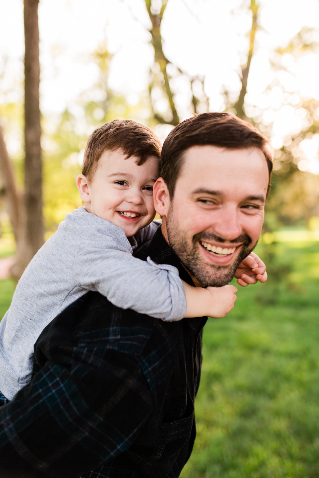  Father gives his son a piggyback ride in the park, Kansas City family photographer, Rebecca Clair Photography 