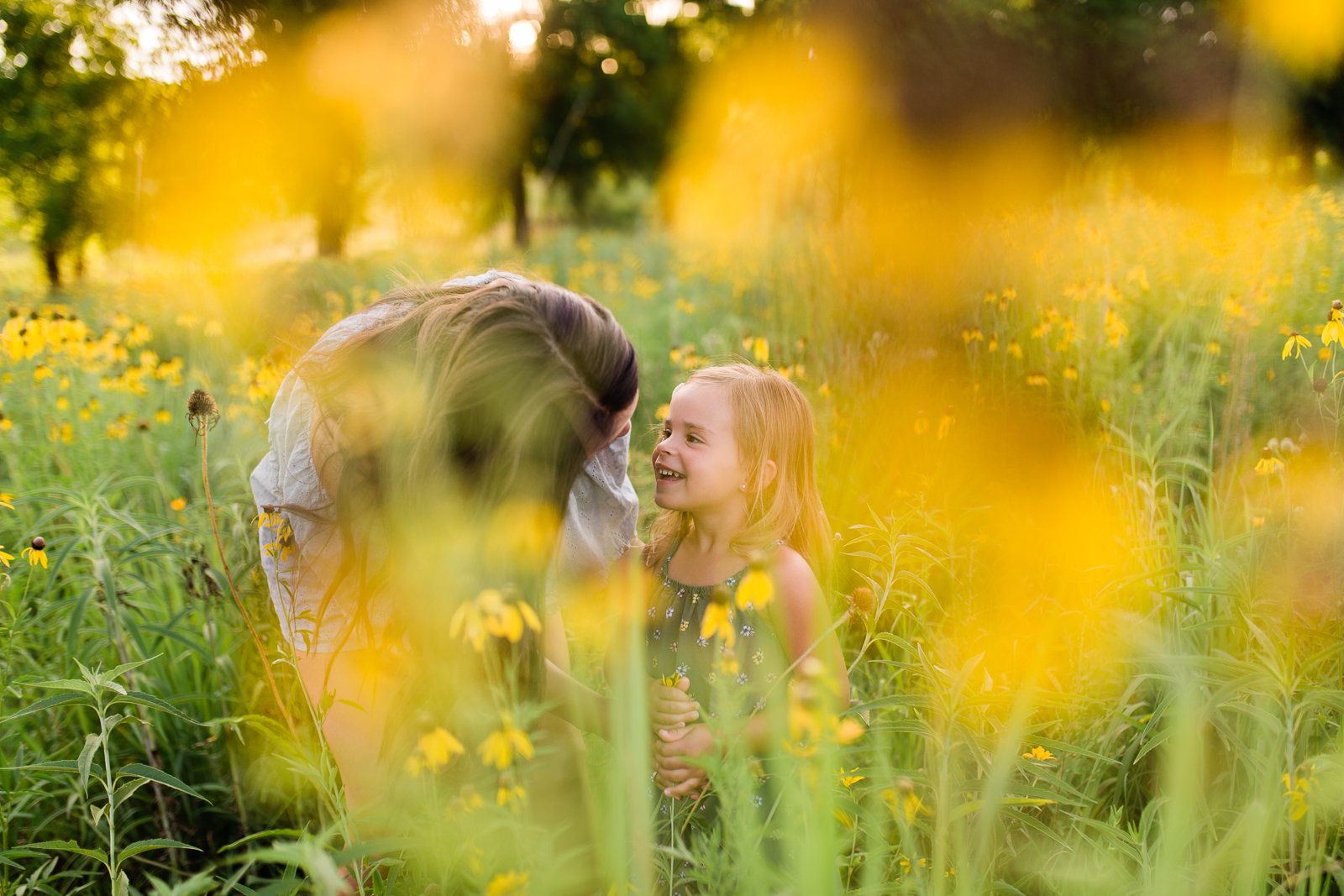  Mother talks to her daughter in a field of flowers, mommy and me session at Shawnee Mission Park, Kansas City lifestyle photographer 