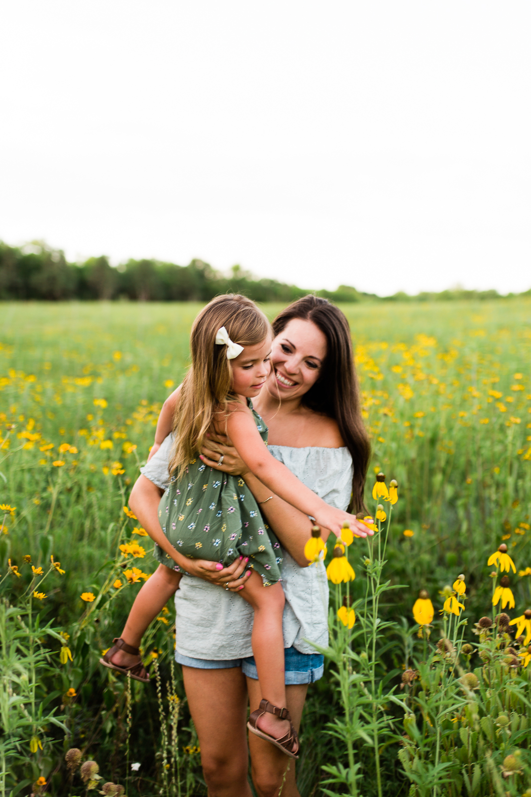  Mother carries daughter in a field of flowers, mommy and me session at Shawnee Mission Park, Kansas City family photographer 