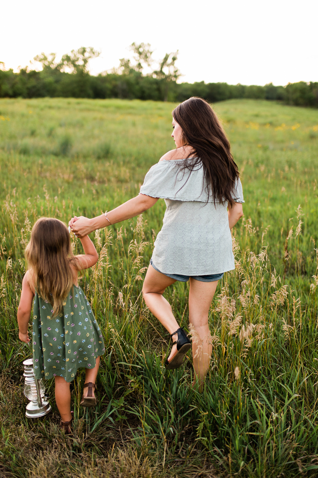  Mother and daughter walking into a field at sunset, mommy and me session at Shawnee Mission Park, Kansas City lifestyle photographer 