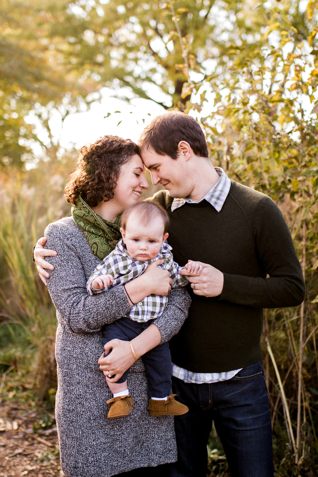  Parents touch foreheads as they hold their infant son, Kansas City lifestyle family photographer, fall family photos, Kansas City lifestyle mini sessions 