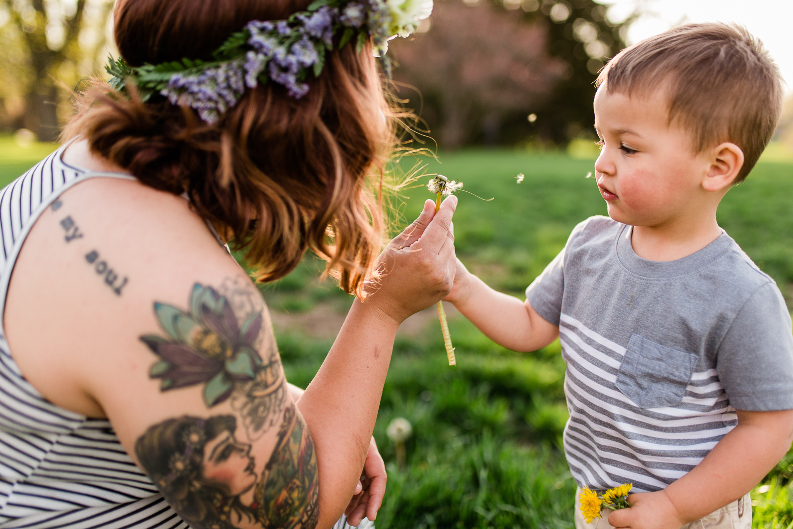  Mother blows dandelion with son at Loose Park, Kansas City lifestyle photographer, candid family photos, golden hour session, Rebecca Clair Photography 