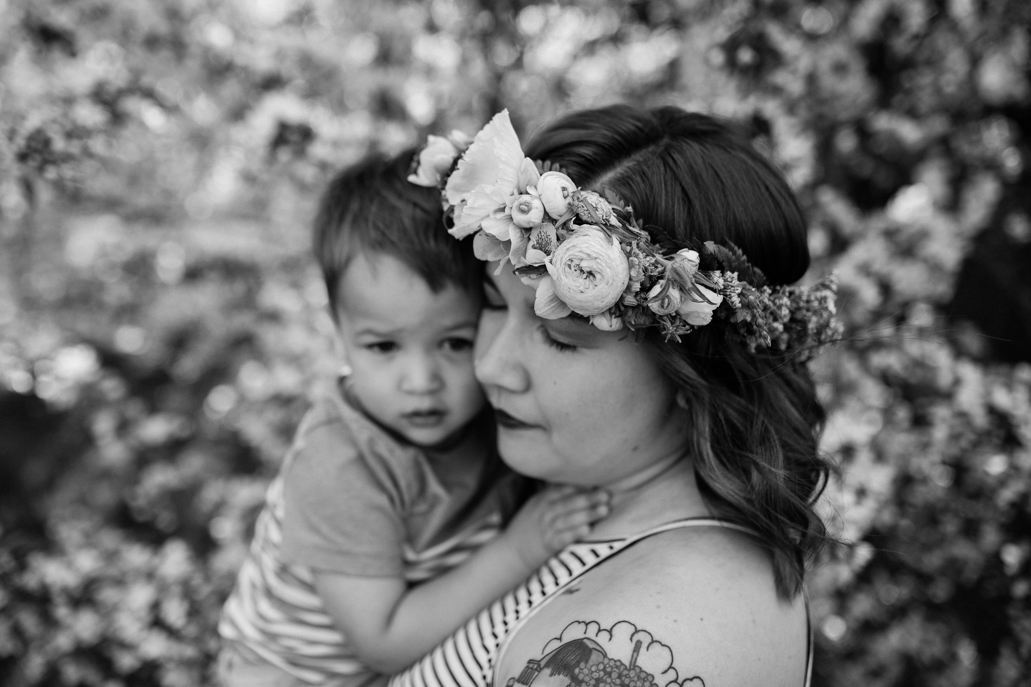  Black and white photo of mother cuddling her son under the flowering trees, Kansas City emotive family photographer, Loose Park, Rebecca Clair Photography 