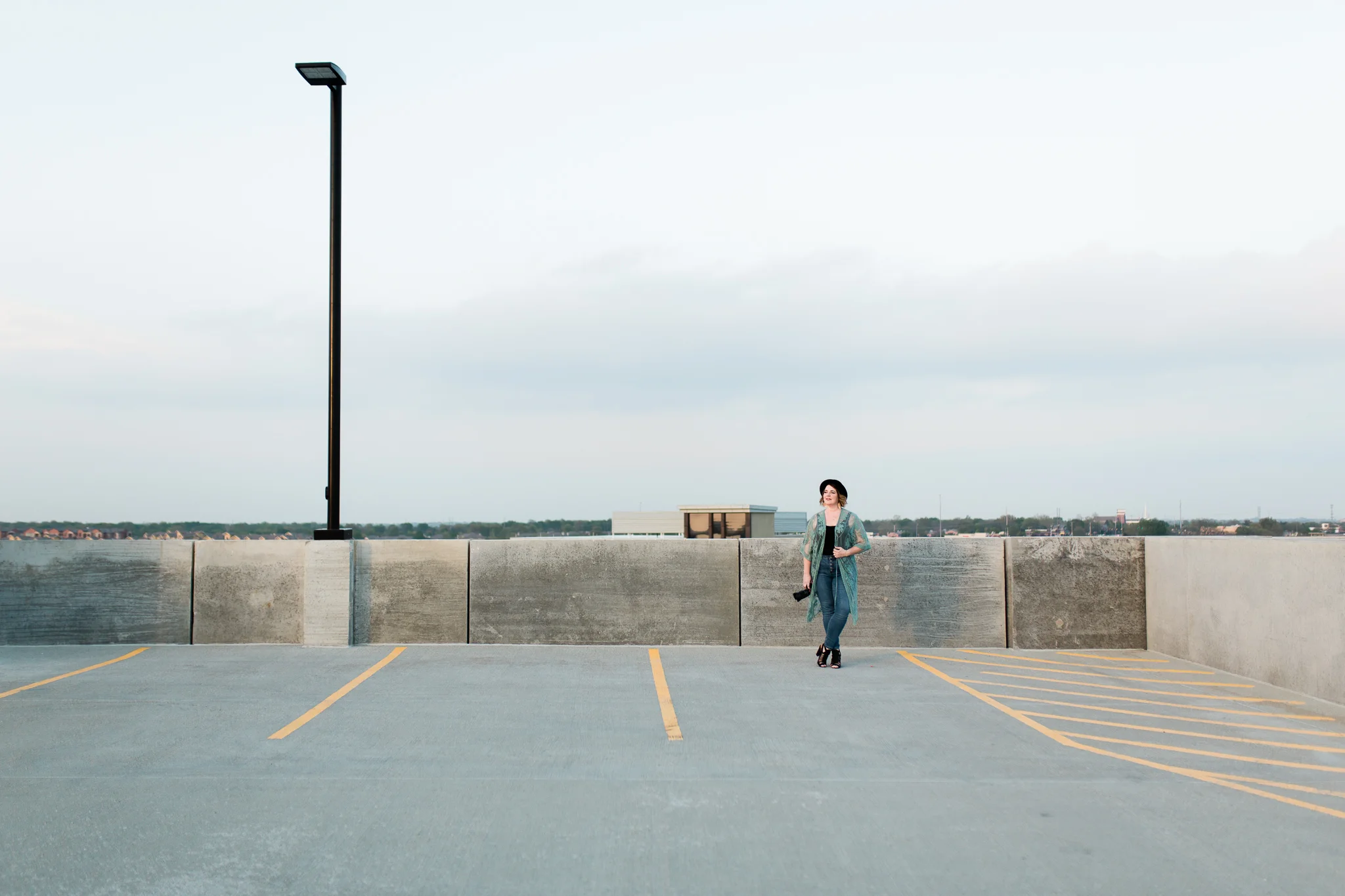 Photographer stands on a rooftop at sunset, Kansas City environmental headshots, Rebecca Clair Photography