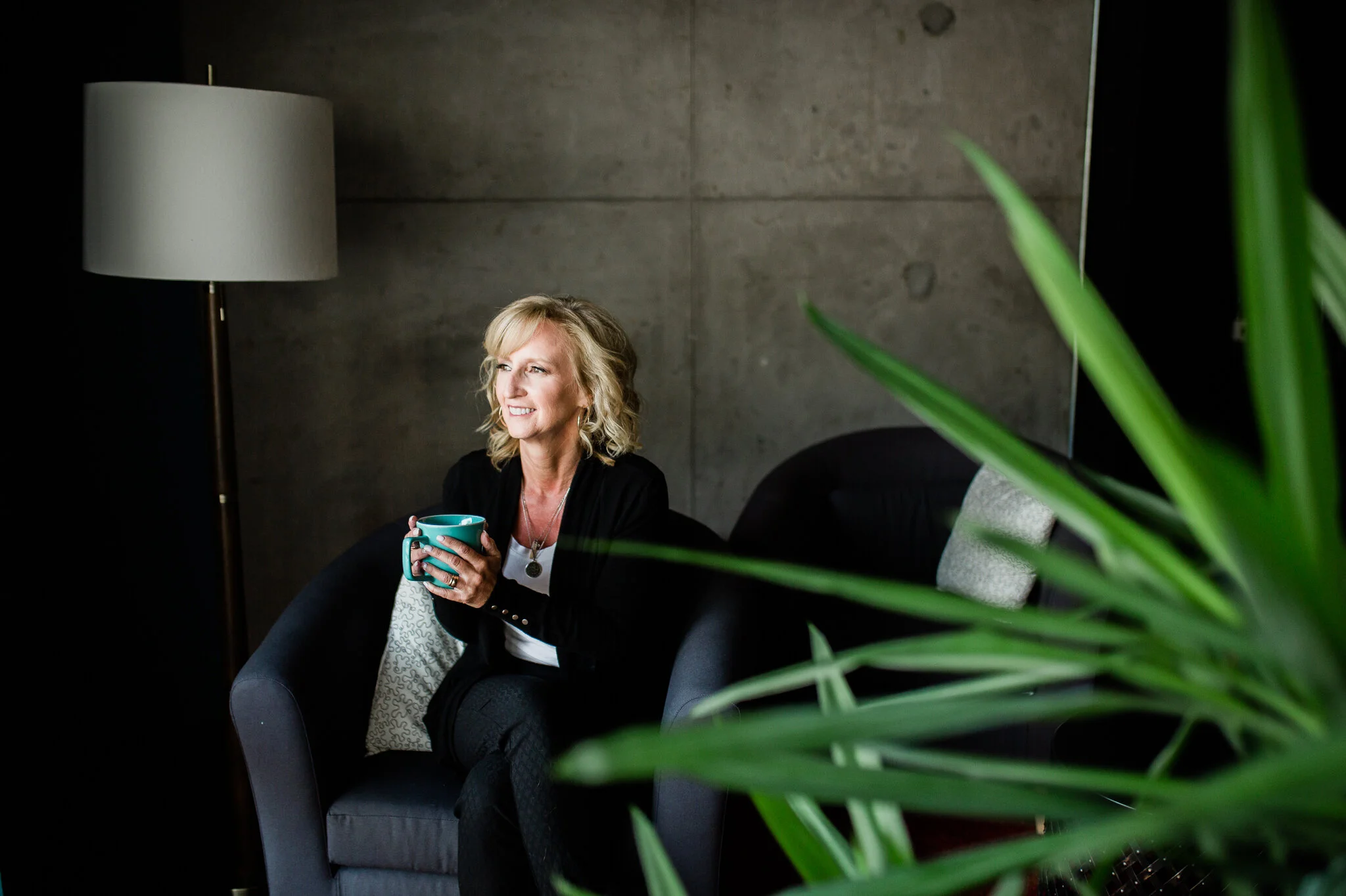 Woman sits in her office holding coffee, Kansas City branding session, Rebecca Clair Photography